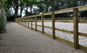 Looking Down Gravel Path With Timber Post & Rail Fence To The Side, All The The Side Of A Equestrian Riding Arena Located In North Yorkshire